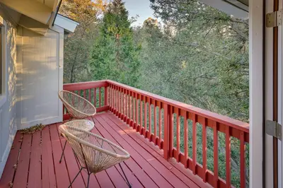 a red deck with two chairs on a house at Crestline Cabin Mountain Views and Fire Pit! in Crestline