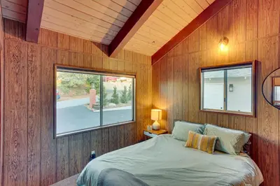 a bedroom with a bed in a wooden wall at Crestline Cabin Mountain Views and Fire Pit! in Crestline