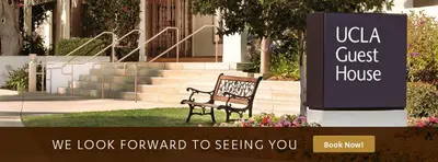 a bench sitting in the grass in front of a building at The Inn at UCLA in Los Angeles