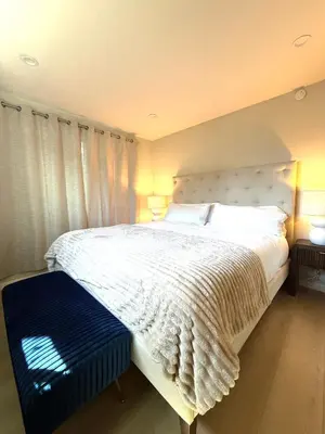 a bedroom with a large white bed with a blue bench at Coastal Escape in Redondo Beach in Redondo Beach