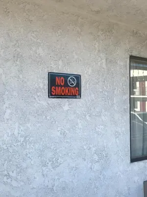 a no smoking sign on the side of a wall at Eunice Plaza Motel in El Monte