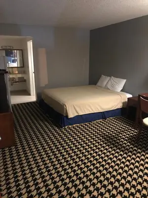 a hotel room with a bed with a checkered floor at Eunice Plaza Motel in El Monte