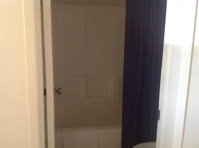 a bathroom with a shower with a toilet and a tub at Eunice Plaza Motel in El Monte