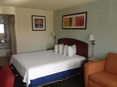 a hotel room with a bed and a chair at Eunice Plaza Motel in El Monte
