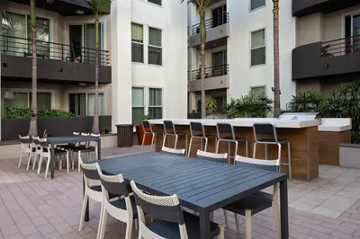 a patio with tables and chairs in front of a building at MDR Studio Apartment Luxury pool, gym, parking, jacuzzi. in Los Angeles