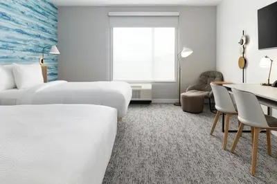 a hotel room with two beds and a desk at TownePlace Suites by Marriott Monrovia in Monrovia