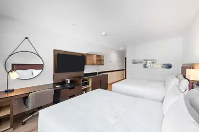 a hotel room with a bed and a desk and a mirror at Hampton Inn Big Bear Lake in Big Bear Lake