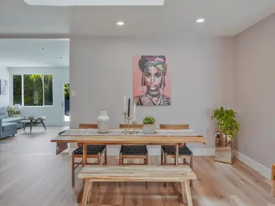 a dining room with a table and a painting on the wall at Hollywood Dream pool home & king beds in Los Angeles