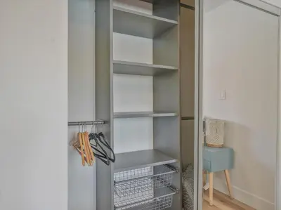 a walk in closet with white walls and gray shelves at Hollywood Dream pool home & king beds in Los Angeles