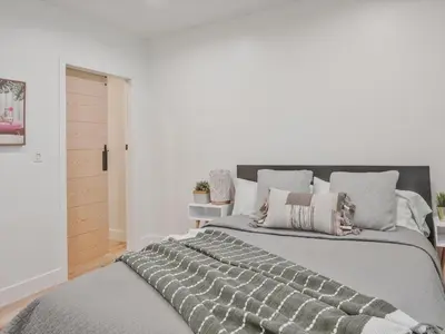 a bedroom with a large gray bed with pillows at Hollywood Dream pool home & king beds in Los Angeles