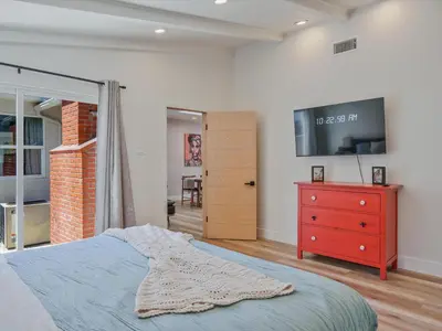 a bedroom with a bed and a tv on the wall at Hollywood Dream pool home & king beds in Los Angeles