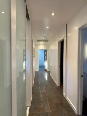 a hallway with white walls and a floor with wood floors at Spacious Resort Getaway @ Echo Park Ranch - Luxury indoor/ outdoor home steps from Sunset Blvd, Echo Park Lake, Dodgers Stadium in Los Angeles