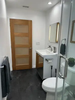 a bathroom with a toilet and a sink and a door at Spacious Resort Getaway @ Echo Park Ranch - Luxury indoor/ outdoor home steps from Sunset Blvd, Echo Park Lake, Dodgers Stadium in Los Angeles