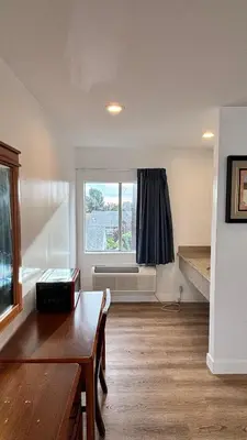 a living room with a table and a window at Budget inn Whittier in Whittier