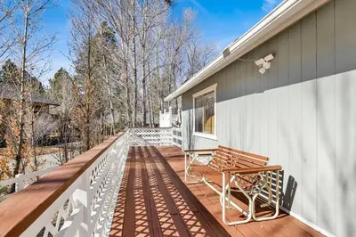a deck with two benches on a house at Divine Chateau Big Bear~ Hot Tub~ Walk to Lake~ in Big Bear Lake