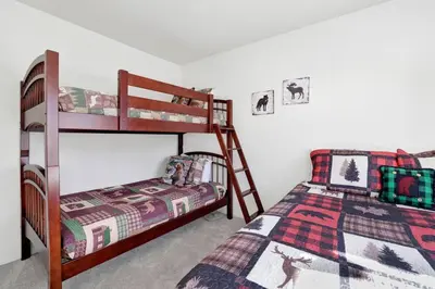 a bedroom with two bunk beds and a bed at Divine Chateau Big Bear~ Hot Tub~ Walk to Lake~ in Big Bear Lake