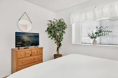 a bedroom with a bed and a mirror and a dresser at Divine Chateau Big Bear~ Hot Tub~ Walk to Lake~ in Big Bear Lake