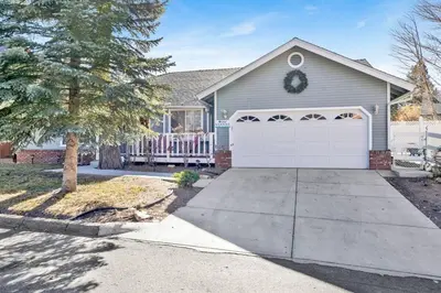a house with a white garage and a tree at Divine Chateau Big Bear~ Hot Tub~ Walk to Lake~ in Big Bear Lake