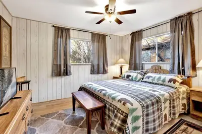 a bedroom with a bed and a ceiling fan at A Hidden Asset Big Bear~ Hot Tub~ Walk to Village~ in Big Bear Lake