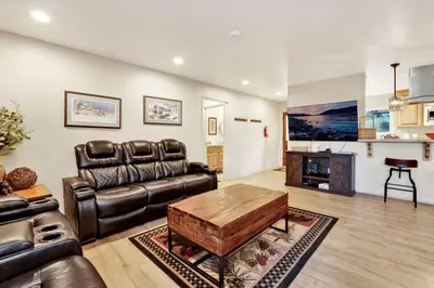 a living room with a leather couch and a coffee table at A Hidden Asset Big Bear~ Hot Tub~ Walk to Village~ in Big Bear Lake