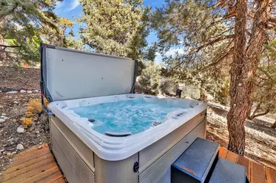 a hot tub sitting on top of a wooden deck at The Octagon Big Bear~ Hot Tub~ Pool Table~Views in Big Bear City