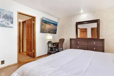 a bedroom with a bed and a desk and a mirror at The Octagon Big Bear~ Hot Tub~ Pool Table~Views in Big Bear City