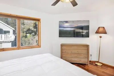 a white bedroom with a bed and a window at The Octagon Big Bear~ Hot Tub~ Pool Table~Views in Big Bear City