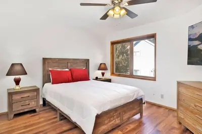 a bedroom with a bed and a ceiling fan at The Octagon Big Bear~ Hot Tub~ Pool Table~Views in Big Bear City
