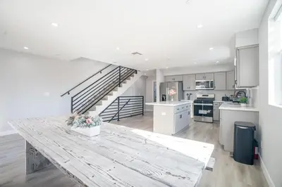 a kitchen with a wooden table and a staircase at Normandie Hostel in Los Angeles
