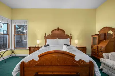 a bedroom with a large wooden bed with white sheets at Mountain High Luxury Castle &Spa in Wrightwood