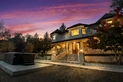 a large house with a sunset in the background at Mountain High Luxury Castle &Spa in Wrightwood