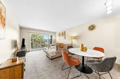 a living room with a table and chairs and a couch at The Moonstone - Cozy Marina side Garden View Pool and Gym in Los Angeles