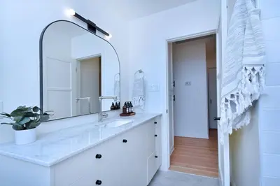 a white bathroom with a sink and a mirror at Beautiful 3 Bed Home with a Large Back Yard Outdoor Space in Los Angeles