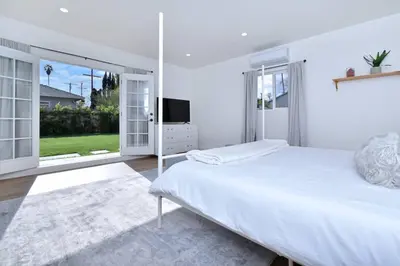 a white bedroom with a large bed and sliding glass doors at Beautiful 3 Bed Home with a Large Back Yard Outdoor Space in Los Angeles