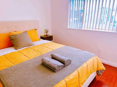 a bedroom with a bed with two towels on it at Charming 3BR Retreat near Disneyland Downtown LA! in Rowland Heights