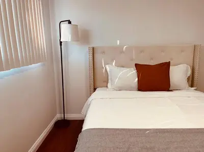 a bedroom with a bed with a red pillow on it at Charming 3BR Retreat near Disneyland Downtown LA! in Rowland Heights