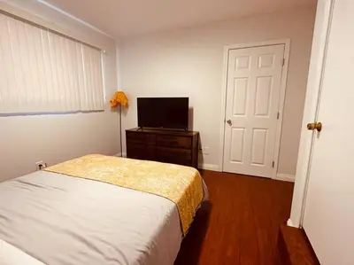 a bedroom with a bed and a flat screen tv at Charming 3BR Retreat near Disneyland Downtown LA! in Rowland Heights
