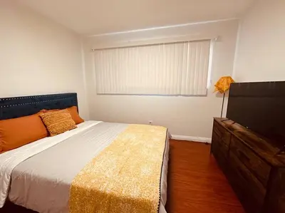 a bedroom with a bed and a flat screen tv at Charming 3BR Retreat near Disneyland Downtown LA! in Rowland Heights