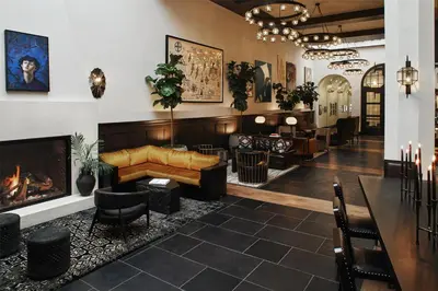 a lobby with a couch and a fireplace at Hotel Figueroa, Unbound Collection by Hyatt in Los Angeles