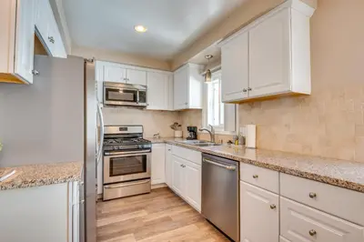 a kitchen with white cabinets and stainless steel appliances at LA Condo about 1 Mi to The Kia Forum and SoFi Stadium in Inglewood