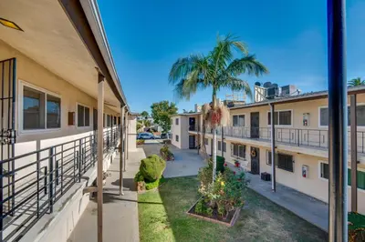 a view of the courtyard of a building with a palm tree at LA Condo about 1 Mi to The Kia Forum and SoFi Stadium in Inglewood