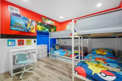 a bedroom with two bunk beds and a desk at Gamers Getaway by OC Adventure Homes in Stanton