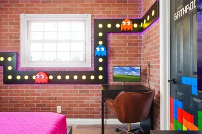 a bedroom with a bed and a desk and a window at Gamers Getaway by OC Adventure Homes in Stanton