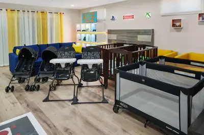 a nursery with chairs and a crib in a room at Gamers Getaway by OC Adventure Homes in Stanton
