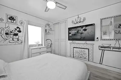 a bedroom with a bed and a tv and a fireplace at The Disneyland Dream by OC Adventure Homes in Garden Grove