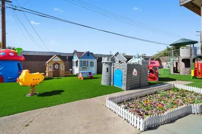 a playground with a garden of flowers in a yard at The Disneyland Dream by OC Adventure Homes in Garden Grove