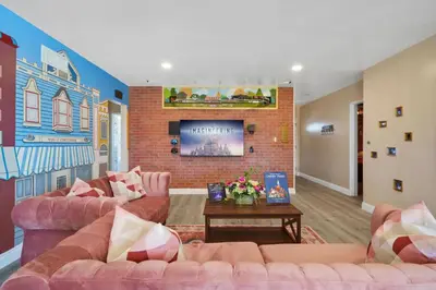 a living room with two couches and a brick fireplace at The Disneyland Dream by OC Adventure Homes in Garden Grove