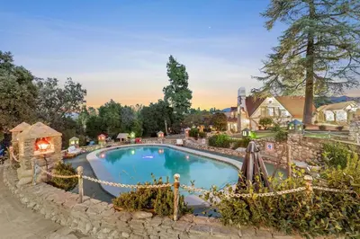 a swimming pool in a yard with a stone wall at The Magic Castle (Unit5) - Six Flags in Newhall
