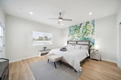 a white bedroom with a large bed and a tv at Incredible Value for 12 guests, New 3BR Home by Disneyland, Knott's, Beach in Midway City