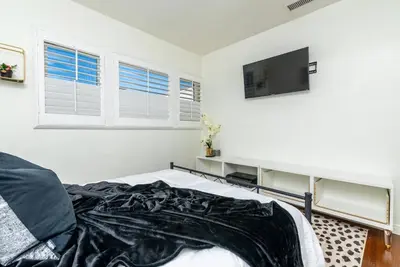 a bedroom with a bed and a flat screen tv at Coastal Retreat With a minimum stay of 30 days in Lakewood